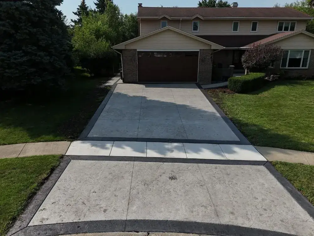 Long concrete drive with control joints leading to a garage
